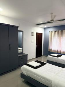 a bedroom with two beds and a mirror at Zarica Homestay in Kannur +4 photos