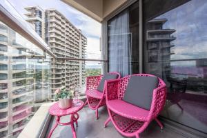 a balcony with three chairs and a table and a window at Dominiks pink dream Studio Balcony Ocean View Balcony Fast-Wifi at Tambuli Resort High Floor in Maribago