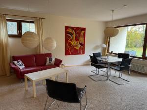 ein Wohnzimmer mit einem roten Sofa und einem Tisch in der Unterkunft Wohnung mit Sonnenterasse in Höchenschwand