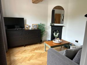 a living room with a television and a fireplace at Bee Cottage - Romsey in Romsey