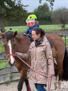 a woman walking a horse with a frog on its back at Relax und Wellness Landhaus in Mettingen