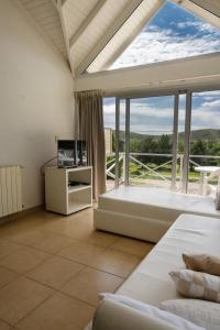 a bedroom with a large window with a bed and a television at Altos de Ventana in Sierra de la Ventana
