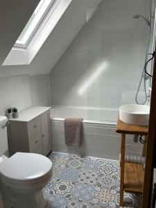 a bathroom with a toilet and a tub and a sink at Bee Cottage - Romsey in Romsey +15 photos