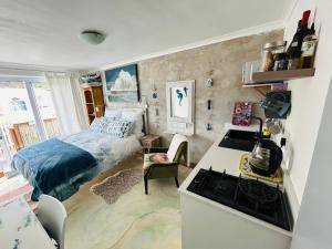a small bedroom with a bed and a kitchen at the Lighthouse Beachroom in Cape Town