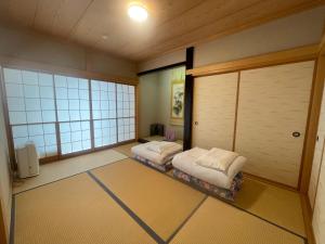 Dos camas en una habitación con dos ventanas. en 富士view 5LDK 河口湖駅まで徒歩圏内 最大10名で一棟貸し, en Fujikawaguchiko