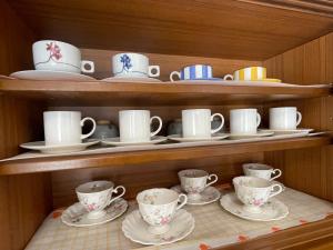 a cupboard with plates and cups and saucers at 旅の宿 富士view 5LDK 河口湖駅まで徒歩圏内 最大10名で一棟貸し in Fujikawaguchiko
