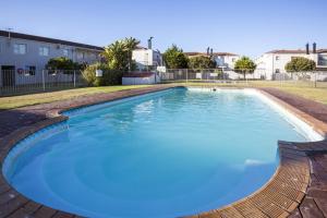 a large pool of blue water in a yard at Sand Castle in Langebaan