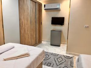 a hotel room with a bed and a tv and a room at energy pyramids view inn in Abū Rawwāsh
