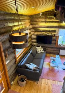 a living room with a couch in a log cabin at Cabin bear's hide in Rovaniemi