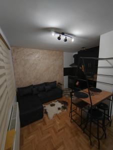 un soggiorno con un divano e un tavolo di Apartman GOBATE a Požarevac