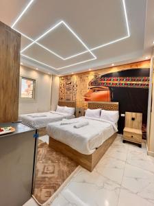 two beds in a room with a wall with a headboard at energy pyramids view inn in Abū Rawwāsh