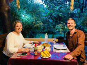 a man and a woman sitting at a table with food at suncity privacy cottages in Udawalawe +54 photos