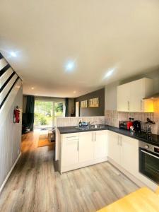 eine Küche mit weißen Schränken und Holzböden in der Unterkunft Newquay Coast and Cabin in Saint Columb Road Station + 58 Fotos