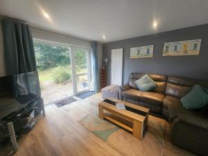 a living room with a couch and a coffee table at Newquay Coast and Cabin in Saint Columb Road Station