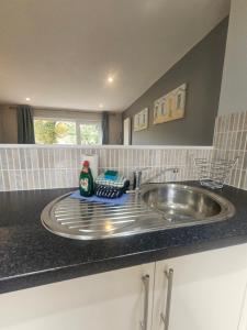 eine Badezimmertheke mit einem Waschbecken und einem Waschbecken in der Unterkunft Newquay Coast and Cabin in Saint Columb Road Station