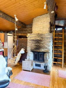 a living room with a stone fireplace in a house at Cabin bear's hide in Rovaniemi