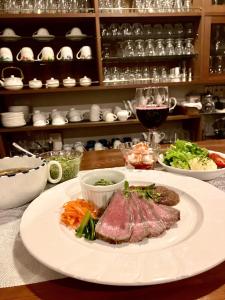 a table with a plate of food and a glass of wine at たんばら高原 ペンション スターガーデン in Numata