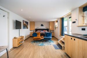 a kitchen and living room with a couch and a chair at Slow Down Texel in Den Burg