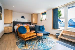 登堡Slow Down Texel的一间卧室,里面有一张床、一张沙发和一把椅子