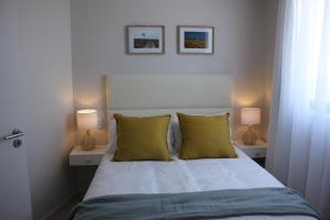 ein Schlafzimmer mit einem Bett mit zwei Lampen in der Unterkunft Luxurious 3-bedroom Bloubergstrand Cape Town beachfront apartment with stunning sea and beach view in Cape Town