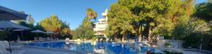 a swimming pool with chairs and trees and a building at Monte Vardia in Chania Town