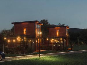 a wooden house with lights in the yard at night at Natura Bungalow in Ždrelo