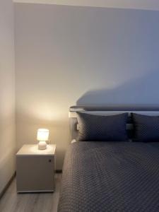 a bedroom with a bed and a lamp on a night stand at Apartment Lana Vareš in Vareš