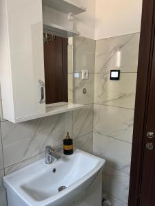 a white bathroom with a sink and a mirror at Apartment Lana Vareš in Vareš +6 photos