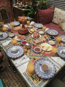 una mesa con platos de comida y tazas de café en Riad Oumkaltoum Fès, en Fez