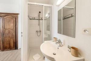 ein weißes Badezimmer mit Waschbecken und Dusche in der Unterkunft Bord De L'Eau 3 et 6 in Cancale + 15 Fotos