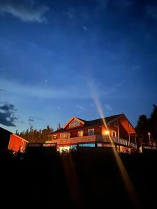 a house with the sun shining on it at night at Lillian's gjestehus, Skibotn in Skibotn