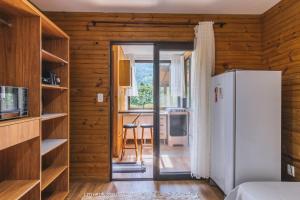 a kitchen with a refrigerator and a table with chairs at Refugio Macacu com Vista para Montanhas in Siriú