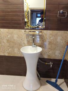 a bathroom with a toilet with a mirror and a mop at Shangarh JC Snow Valley in Shangarh