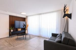 Un televizor și/sau centru de divertisment la דירת סטודיו יוקרתית עם נוף לים ובריכה מחוממת דקה מהחוף