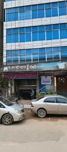 two cars parked in front of a building at Sea Shell Hotel - Sales & Booking Office in Bāiljuri