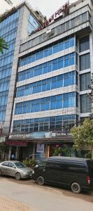 a building with two cars parked in front of it at Sea Shell Hotel - Sales & Booking Office in Bāiljuri
