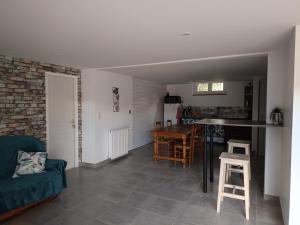 a living room with a blue couch and a kitchen at Appartement Cosy chez Nicolas et Aline in Pompiey