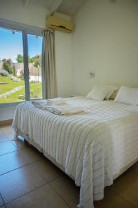 a bed in a room with a large window at Altos de Ventana in Sierra de la Ventana