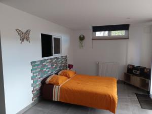 a bedroom with a bed with an orange blanket at Appartement Cosy chez Nicolas et Aline in Pompiey