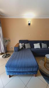 a living room with a blue couch and a blue ottoman at Serenity Homes in Kampala