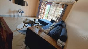 a living room with a blue couch and a table at Serenity Homes in Kampala +6 photos