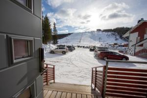 a view from a balcony of a ski resort with cars parked at Ski Center Alpine Houses B2 in Kittilä