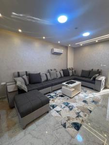 a living room with a couch and a table at Pearl pyramids Suites in Ghaţāţī +3 photos