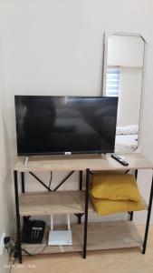 einen Schreibtisch mit einem TV darüber in der Unterkunft Sunvida Cebu in Cebu City
