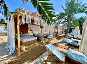 ein Resort mit Bett, Stühlen und Palmen in der Unterkunft Luxury rest Dolphin Club in Sonnenstrand