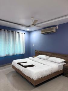 a bedroom with a large bed with a blue wall at Zarica Homestay in Kannur
