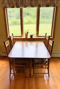a dining room table with chairs in front of a window at Mountain Retreat in the Catskills in Roxbury