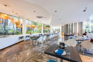 un restaurant avec des tables et des chaises et de grandes fenêtres dans l'établissement Dominiks pink dream Studio Balcony Ocean View Balcony Fast-Wifi at Tambuli Resort High Floor, à Maribago