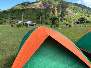 an orange and green tent sitting in a field at Happy Valley Camping Tents in Araku