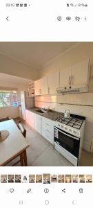 Una cocina con gabinetes blancos y un horno de estufa. en LodeMingo, en San Pedro